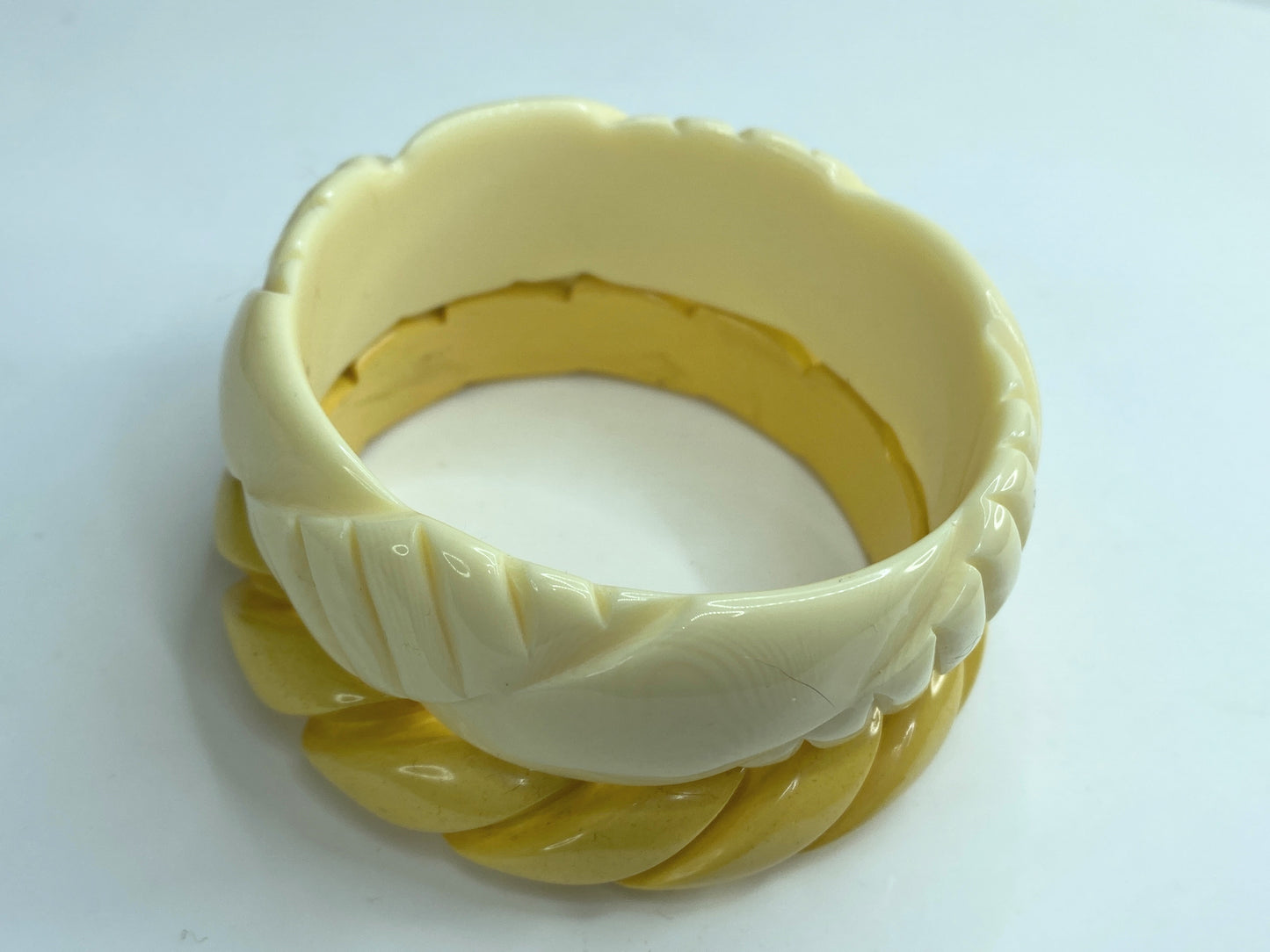 Pair of carved celluloid faux ivory and Honey Bakelite bangles GS184