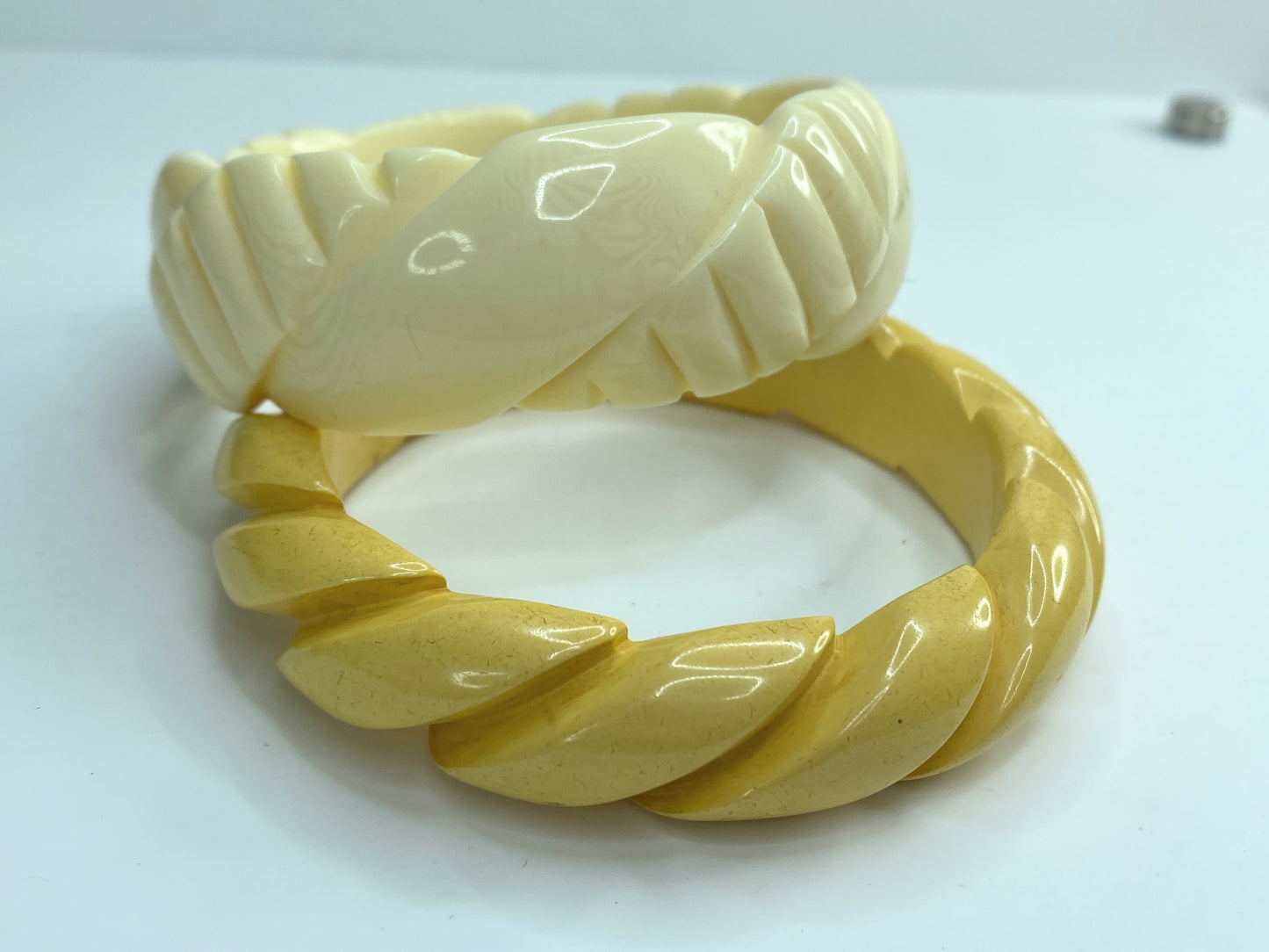 Pair of carved celluloid faux ivory and Honey Bakelite bangles GS184