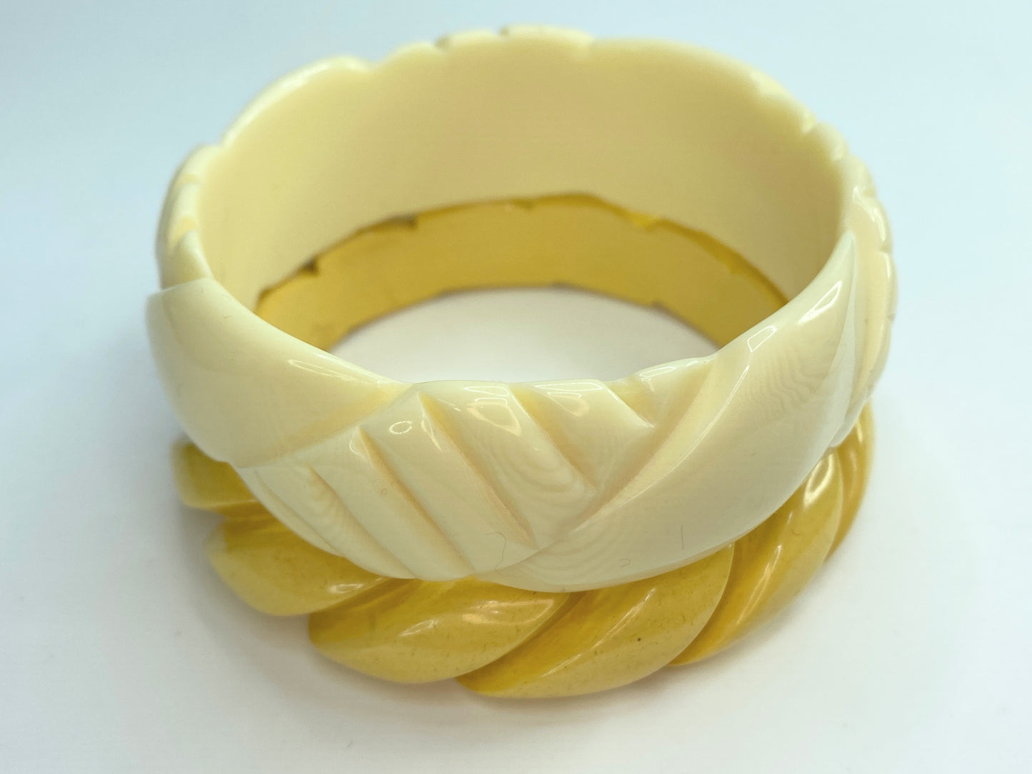 Pair of carved celluloid faux ivory and Honey Bakelite bangles GS184