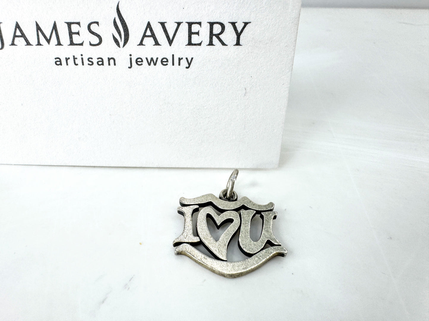 JR1923 - James Avery sterling silver “I Love You” charm pendant with open heart center design. Marked AVERY 925; approx. 19 x 17mm; 2.1g.