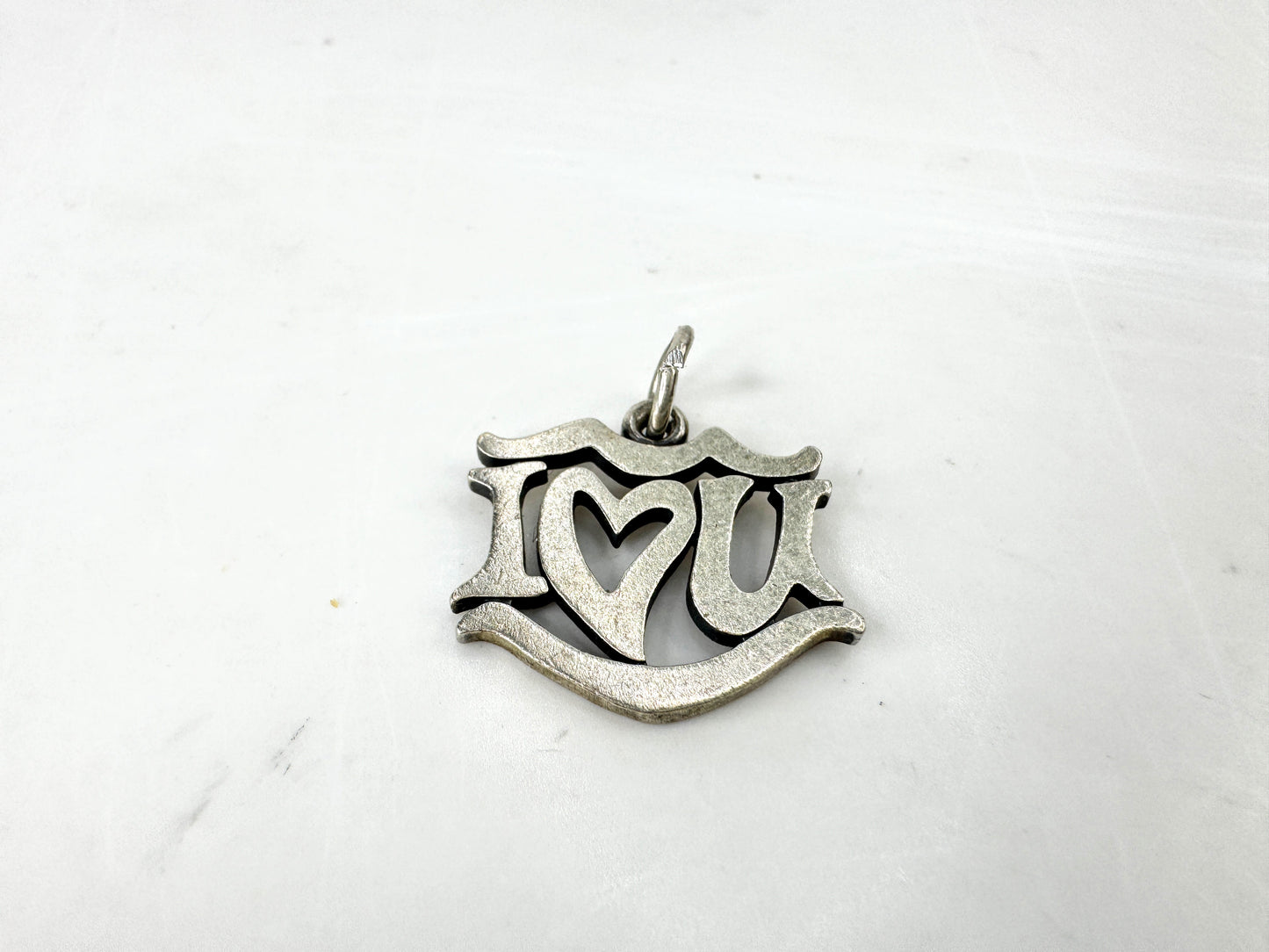 JR1923 - James Avery sterling silver “I Love You” charm pendant with open heart center design. Marked AVERY 925; approx. 19 x 17mm; 2.1g.